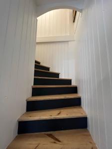 un escalier menant à une chambre aux murs blancs. dans l'établissement LE PHARE DE LA COTINIERE - Proche port et centre ville, à La Flotte
