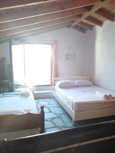 two beds in a room with a window at Rebekka's Guest House Elani in Siviri