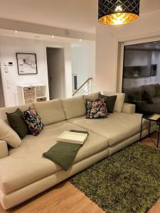 a living room with a brown couch with pillows at Ferienwohnung in Neubau in Schellenberg