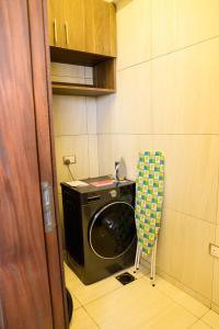 a laundry room with a washing machine and a chair at Exquisite 2BD at Skynest Residences with rooftop heated pool in Nairobi