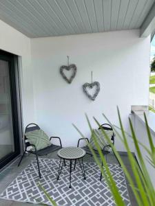 un patio con mesa y 2 corazones en la pared en Ferienwohnung in Neubau, en Schellenberg
