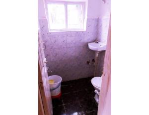 baño con aseo y lavabo y ventana en Hotel Prem Rose, Pahalgam, en Pahalgām