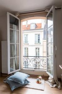 ein offenes Fenster mit Blick auf ein Gebäude in der Unterkunft Le Lumineux 50 m² Gare/château/wifi/Netflix in Versailles