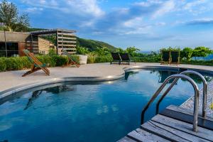 una piscina con 2 sillas junto a ella en Villa Balis Crema Verona Hills, en Grezzana