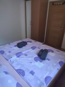 a bed with two pairs of shoes on it at Počitniško stanovanje Aurora in Bovec