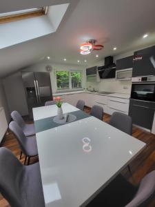 a kitchen with a white table and chairs at Green Garden House in Zreče +29 photos
