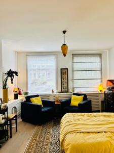 a bedroom with a bed and two couches and yellow pillows at Leiden City Centre Canal View or Terrace View Apartments in Leiden