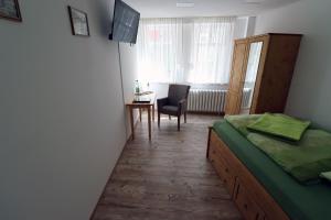 1 dormitorio con cama, escritorio y silla en Gästezimmer zum rotem Karpfen, en Erfurt