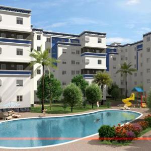 ブズニカにあるAppartement avec piscine à bouznikaの大きな建物の前のプール