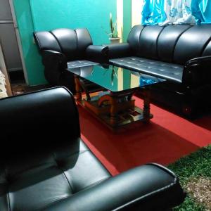 sala de estar con sillas de cuero negro y mesa de cristal en OYO Home Narayan Homestay & Adventures en Pelling