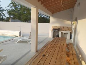 eine Terrasse mit Holzboden neben einem Pool in der Unterkunft Villa Pascal mas Bories Albi # Piscine # Clim # Wifi #10 personnes in Albi