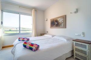 um quarto com 2 camas e uma janela em Villa Vista Golf Salobre - Maspalomas self-sufficient with pool heating em Maspalomas