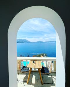 un tavolo e sedie su un balcone con vista sull'oceano di Kanakis Apartments ad Ásos