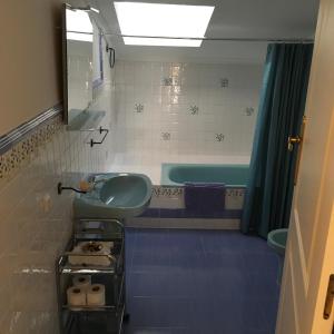 a bathroom with a green sink and a tub at Casa Maria in Camuñas