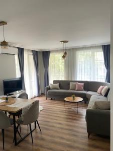 a living room with a couch and a tv at M&M Center Apartment with free parking in Plovdiv