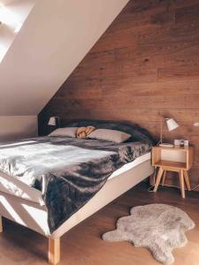 een slaapkamer met een groot bed en een houten muur bij Riverside Apartment In The Heart of Old Town in Klaipėda