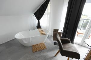 W łazience znajduje się biała wanna i krzesło. w obiekcie D8 B&B w mieście Zadar