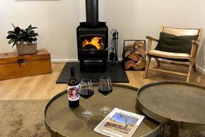 a living room with two glasses of wine and a fireplace at Kidman's Rest in The Range