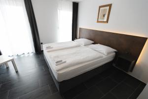 una camera con letto e testiera in legno di D8 B&B a Zara (Zadar)