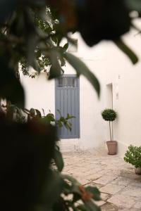 une porte dans un bâtiment blanc avec une plante en pot dans l'établissement Le Cementine - Apulian Rooms, à Fasano