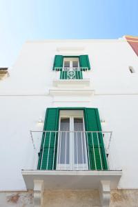 una ventana con persianas verdes en un edificio blanco en Le Cementine - Apulian Rooms, en Fasano