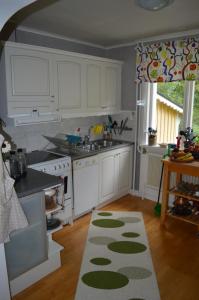 a kitchen with white cabinets and a rug on the floor at Humlebo in Boda Glasbruk