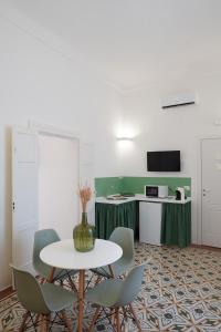 Habitación con mesa, sillas y cocina. en Le Cementine - Apulian Rooms, en Fasano