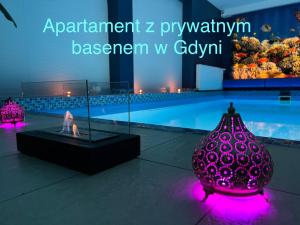 fioletową szklaną wazę siedzącą obok basenu w obiekcie Sopot Spa Apartament w mieście Sopot