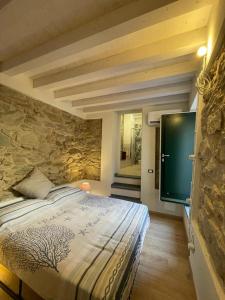 um quarto com uma cama e uma parede de pedra em VistaMare & Relax Cinque Terre SeaView & Relax Cinque Terre em Vernazza