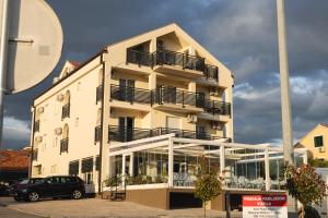 biały budynek z balkonami i samochód zaparkowany przed budynkiem w obiekcie D8 B&B w mieście Zadar