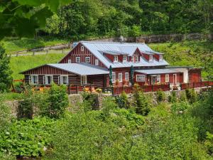 a large red house with a train in front of it at Pension Modrá Hvězda in Dolní Malá Úpa