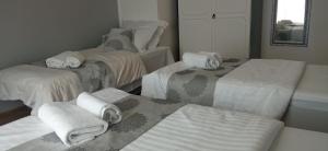a room with three beds with towels on them at Apartman Magnolija in Rijeka