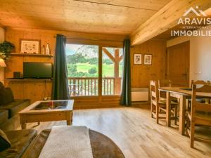 a living room with a table and a large window at Appartement Le Grand-Bornand, 3 pièces, 4 personnes - FR-1-391-103 in Le Grand-Bornand