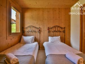 two beds in a room with wooden walls at Appartement Le Grand-Bornand, 3 pièces, 4 personnes - FR-1-391-103 in Le Grand-Bornand