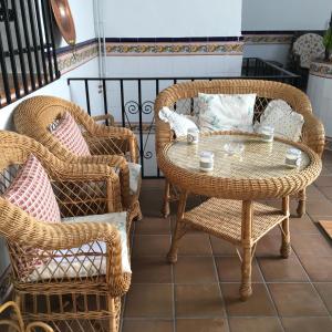 un patio con sillas de mimbre y una mesa en Casa Maria, en Camuñas