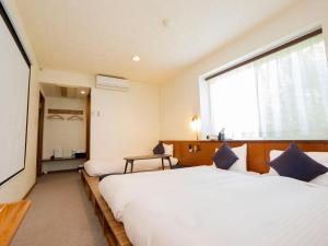 um quarto com 2 camas e uma grande janela em We Home Villa ～城ケ崎温泉～ em Futo