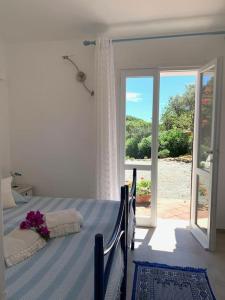 een slaapkamer met een bed en een deur met een raam bij Villa Margiu in Villasimius