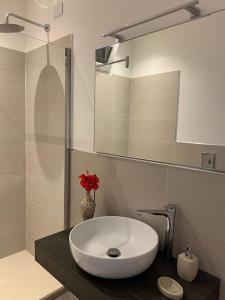 uma casa de banho com um lavatório branco e um espelho. em Villa Margiu em Villasimius