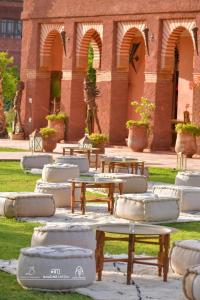 a group of picnic tables in front of a building at LES JARDINS DE MARRAKECH in Marrakesh