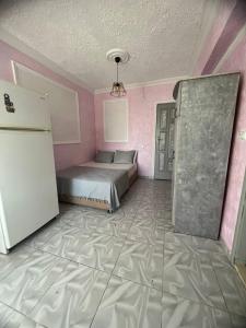 ein Schlafzimmer mit einem Bett und einem Kühlschrank. in der Unterkunft Duran Apart in Antalya