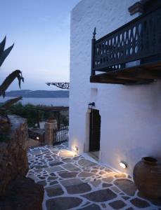 a building with a stone courtyard with a balcony at Castrum Traditional Sunset Suites in Plaka Milou