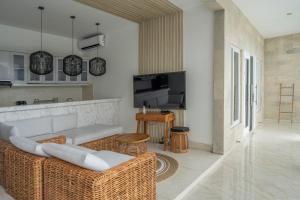 ein Wohnzimmer mit einem Sofa und einem TV in der Unterkunft SILENCIO - Bali Invest Club in Canggu
