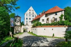 una grande casa bianca con un grande edificio di Schweizer´s Ferienwohnung ad Achberg