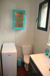 uma casa de banho com um WC branco e um lavatório. em STUDIO LUXE 600M PLAGE AVEC SPA POUR 4 PERS em Cap d'Agde