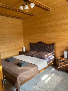 ein Schlafzimmer mit einem Bett in einem Holzzimmer in der Unterkunft Tomashchuk resort in Worochta