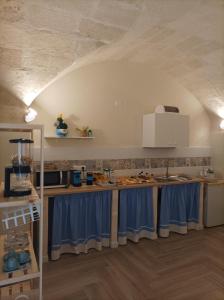 una cocina con cortinas azules en las encimeras en Casa KaLu', en Crispiano