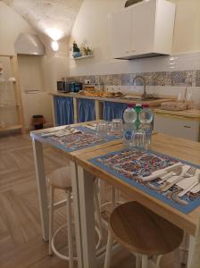 una cocina con una mesa con copas de vino. en Casa KaLu', en Crispiano