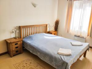 a bedroom with a bed with two towels on it at Терасите - Къща 1 in Ribarica