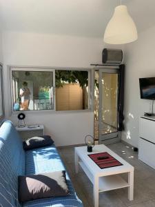 Una sala de estar con un sofá azul y una mesa. en Chez Anne, en La Ciotat 14 fotos más