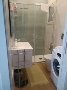 ein Badezimmer mit einer Dusche, einem Waschbecken und einer Waschmaschine in der Unterkunft Casa IRENE in Giardini-Naxos